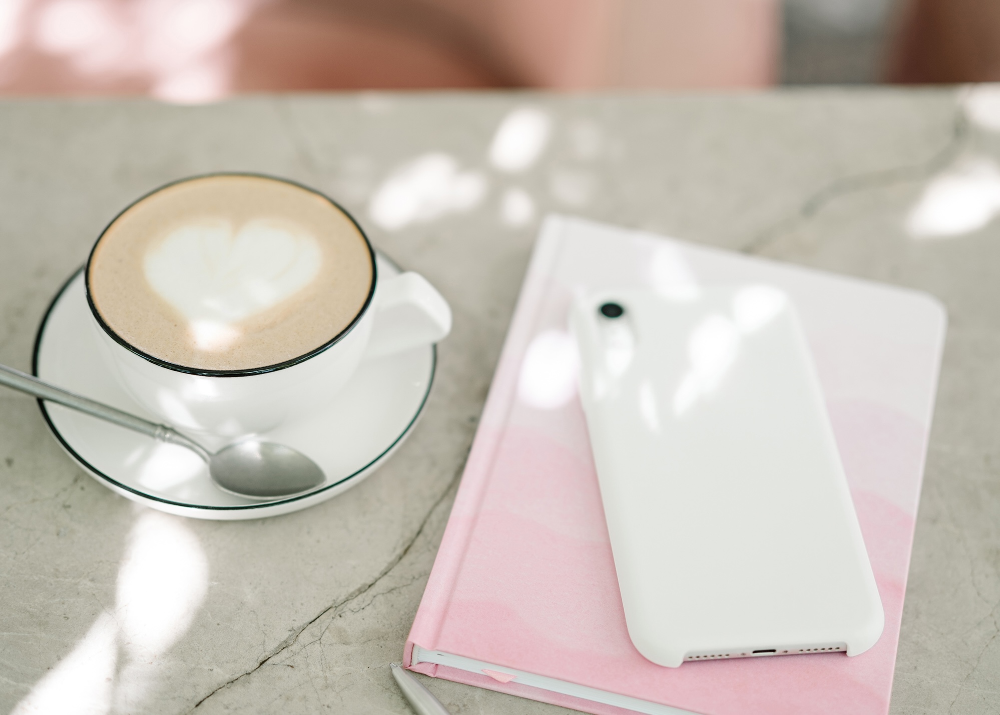 Coffee cup on a table with iPhone and diary